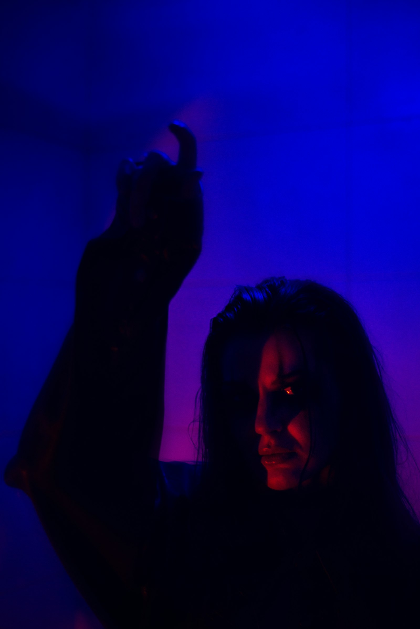 Woman holding a phone in a dark room.