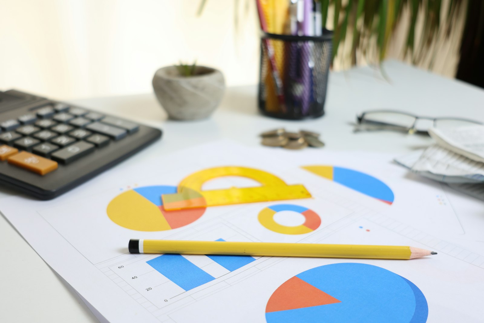 Calculator, charts, and pencil arranged on a desk during financial review.