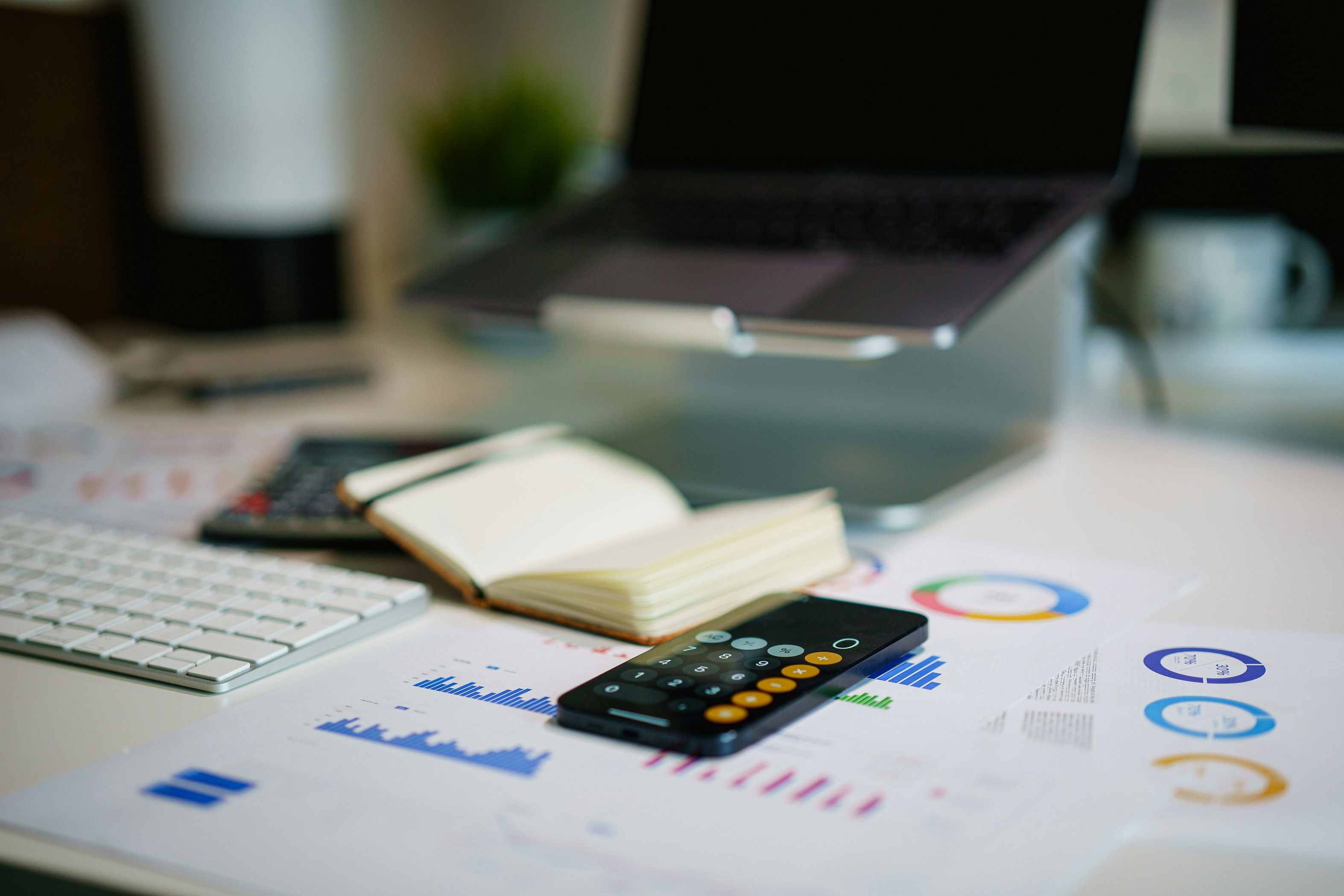 Financial professional reviewing analytics on a tablet with accounting documents and calculator nearby.